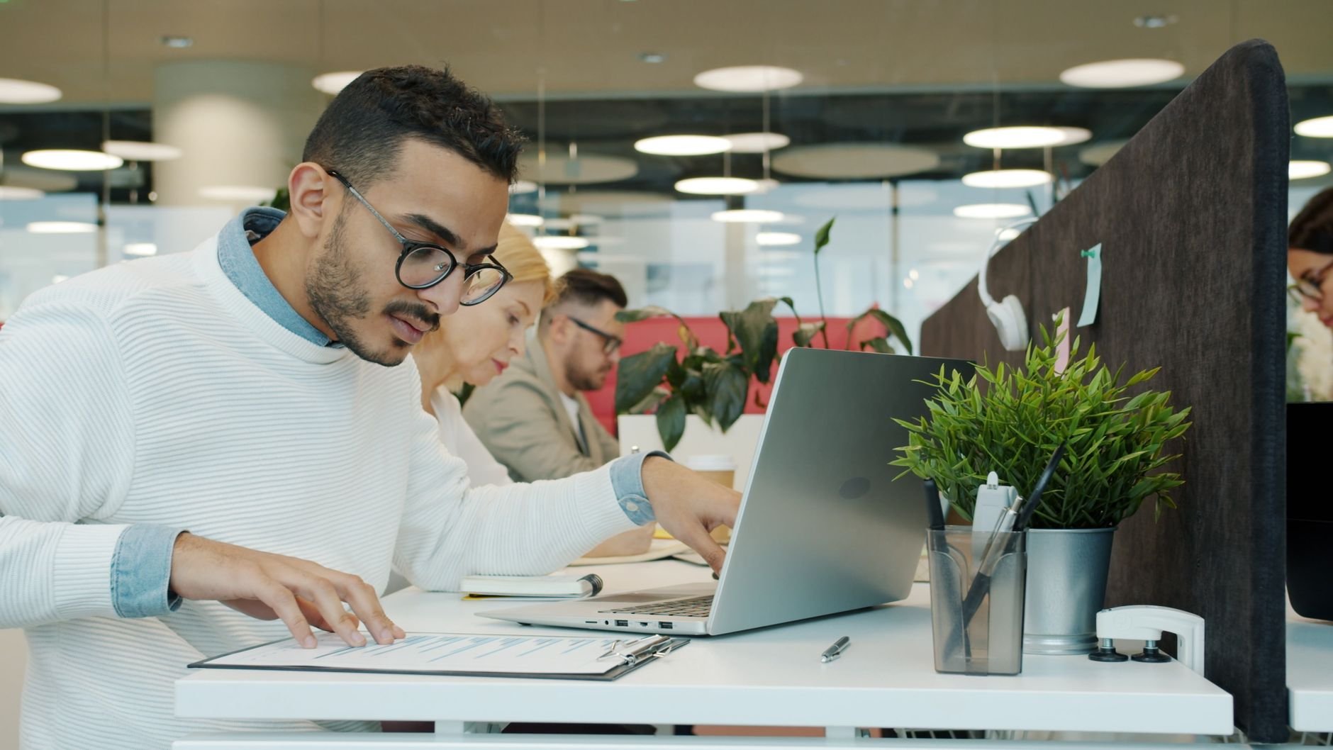 Diverse team of professionals working diligently in a modern open office setting.